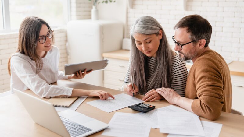 Insurance agent consulting mature family couple, discussing health insurance, signing contract deal